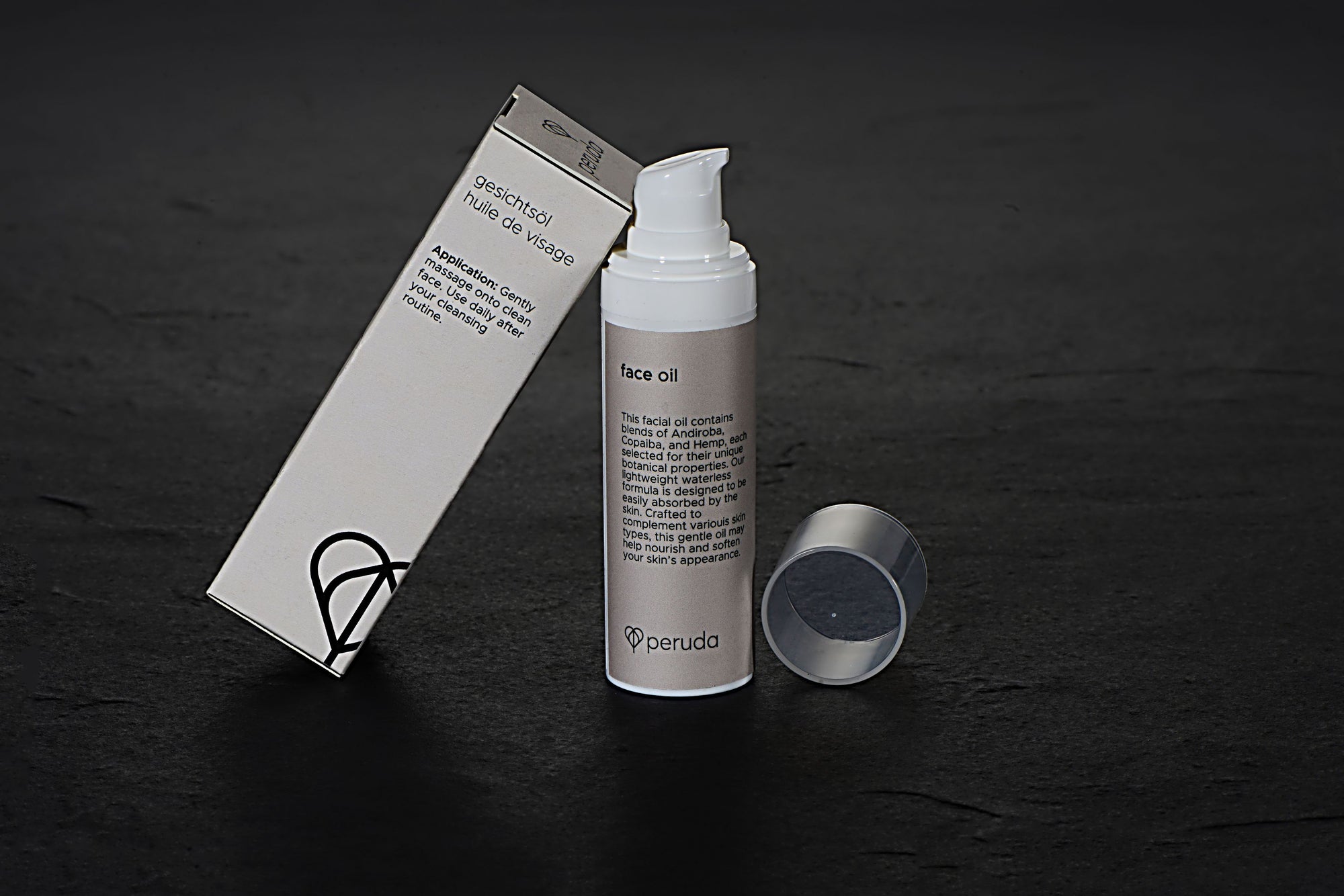 Peruda face oil in a white pump bottle next to a beige box.