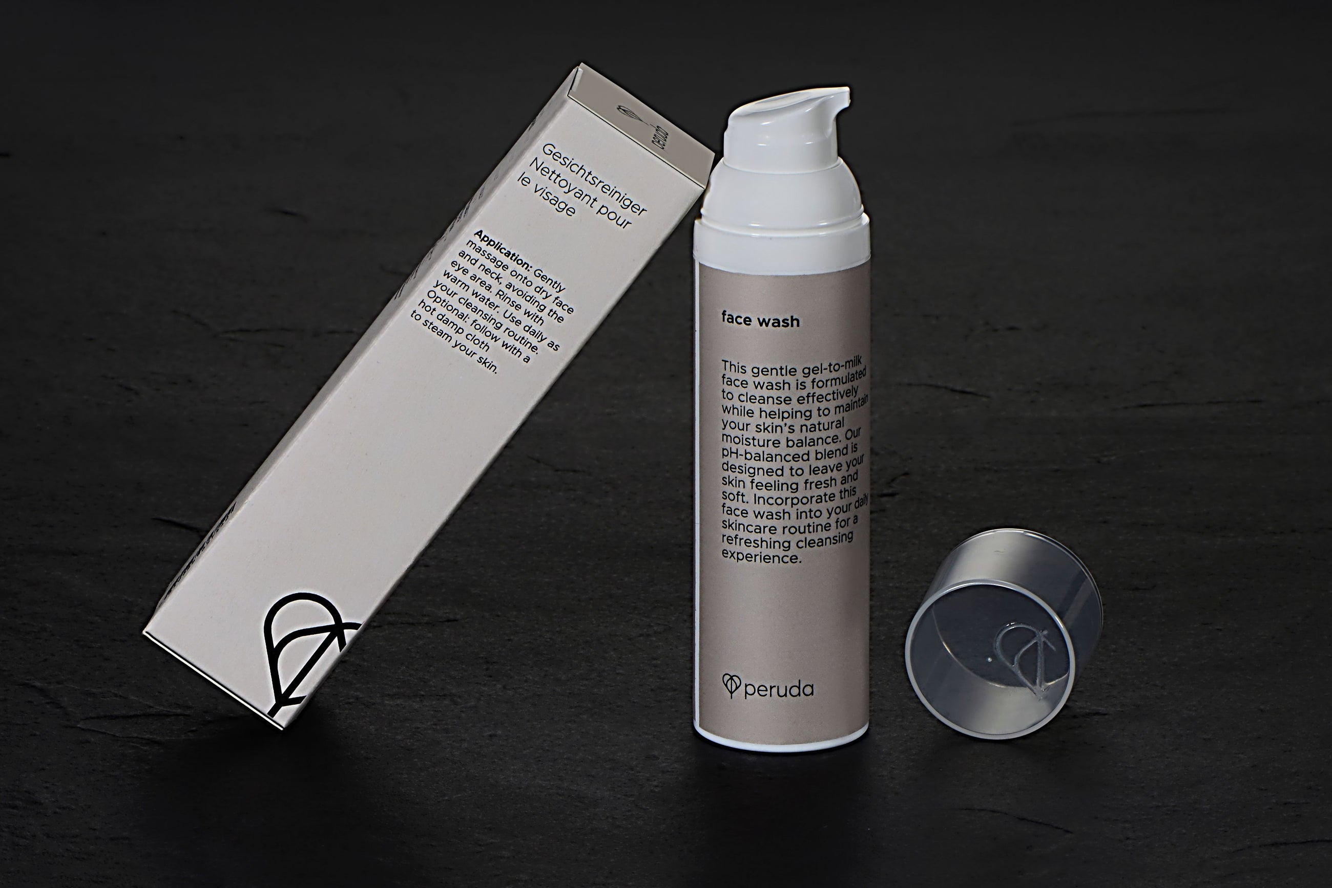 Face wash in a white pump bottle next to a beige box.