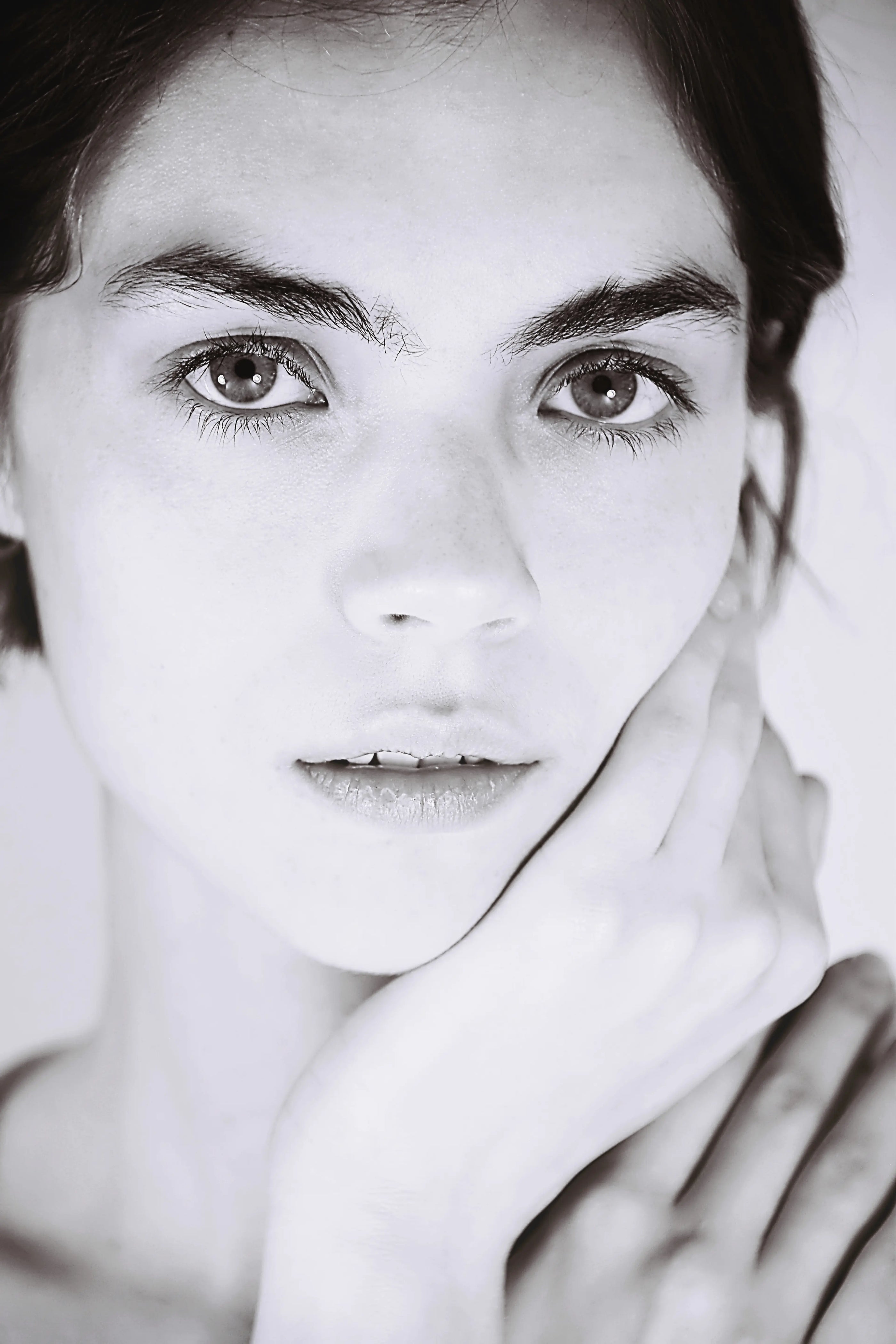 Black and white portrait of a woman with her hand on her face.