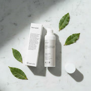 peruda skincare face wash with neem in a white pump bottle and box on a neutral linen background with green leaves